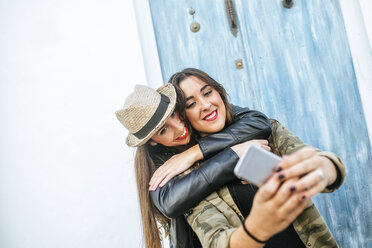 Two happy young women taking a selfie with a smart phone - KIJF01129