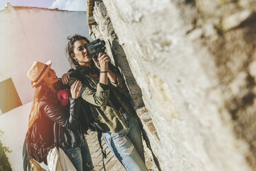 Junge reisende Frauen, die mit einer alten Videokamera aufnehmen - KIJF01159
