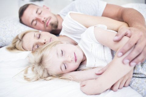 Familie schläft im Bett, lizenzfreies Stockfoto