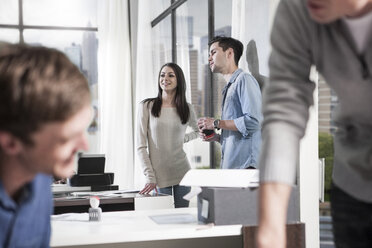 Kollegen unterhalten sich in einem modernen Büro - ZEF12500