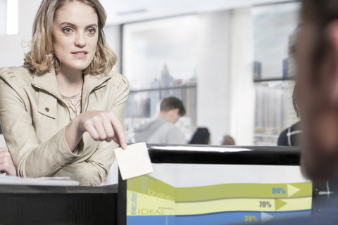 Young woman in office looking at colleague stock photo