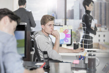 Young man at office desk thinking - ZEF12519