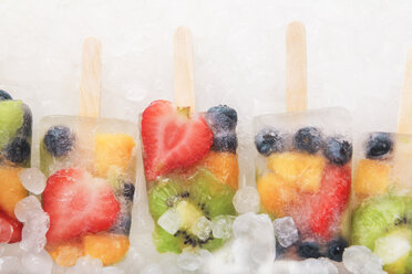 Row fruit ice lollies with fresh fruits on white ground - RTBF00613