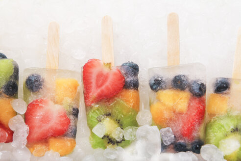 Row fruit ice lollies with fresh fruits on white ground - RTBF00613