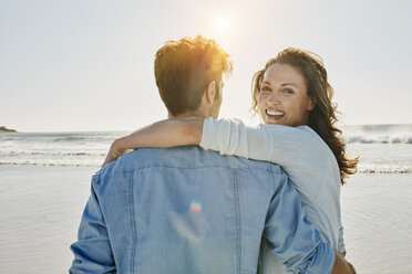 Porträt einer glücklichen Frau mit ihrem Partner am Strand - RORF00542