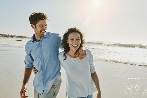 Laughing couple on the beach stock photo