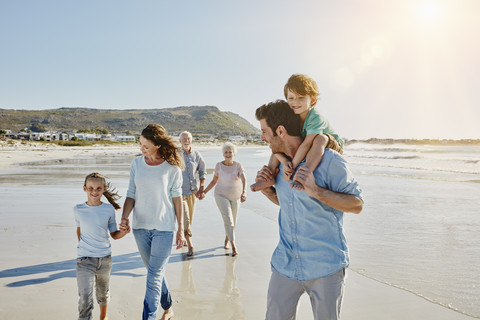Drei Generationen Familie beim Spaziergang am Strand, lizenzfreies Stockfoto
