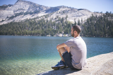 USA, Kalifornien, Yosemite National Park, Mann sitzt an einem Bergsee - EPF00296