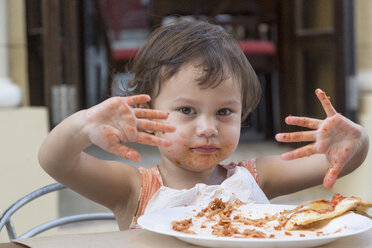 Porträt eines kleinen Mädchens, das Spaghetti mit den Fingern isst - DRF01721
