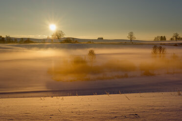 Deutschland, Gebrazhofen, Sonnenaufgang über dunstiger Winterlandschaft - SIEF07271