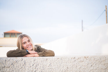 Spain, Tenerife, portrait of young blond woman leaning on wall - SIPF01365