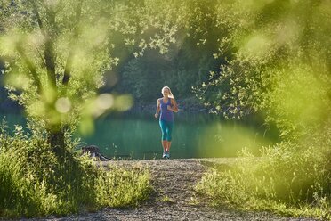 Deutschland, Bayern, Junge Frau beim Joggen am Walchensee - MRF01678