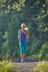 Deutschland, Bayern, Junge Frau beim Joggen am Walchensee - MRF01679