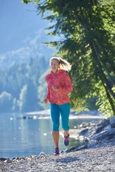 Deutschland, Bayern, Junge Frau beim Joggen am Walchensee - MRF01680