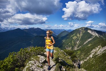 Germany, Bavaria, Young woman running in the mountains - MRF01684