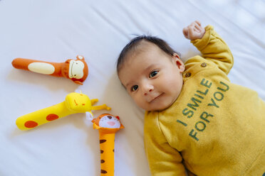 Babymädchen mit Spielzeug auf dem Bett - GEMF01459
