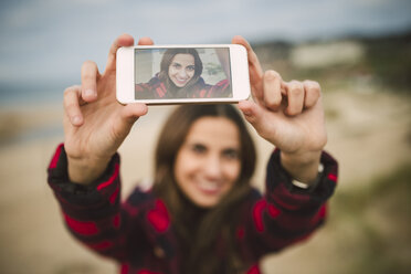 Photography of young woman taking a selfie on display of smartphone - RAEF01685