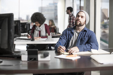 Man with pencil at desk in office thinking - ZEF12561