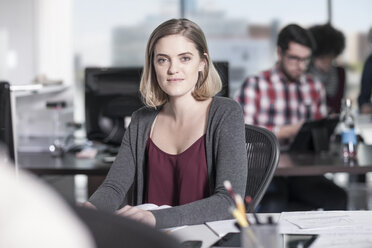 Porträt einer lächelnden Frau am Schreibtisch im Büro - ZEF12569