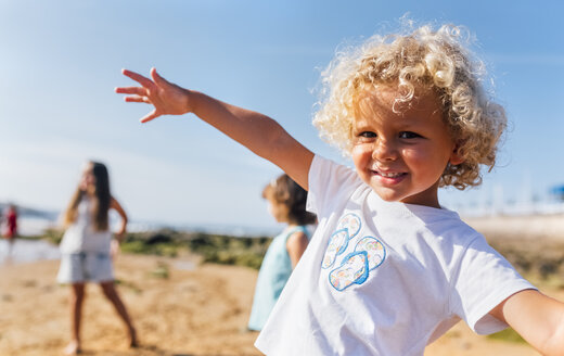 Porträt eines glücklichen kleinen Jungen am Strand - MGOF02835