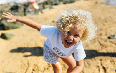 Porträt eines lachenden kleinen Jungen am Strand - MGOF02837