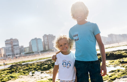 Porträt von zwei glücklichen Brüdern am Strand - MGOF02838