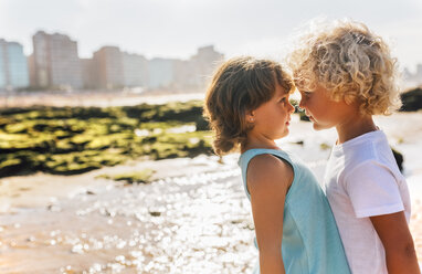 Kleiner Junge und Mädchen von Angesicht zu Angesicht am Strand - MGOF02840