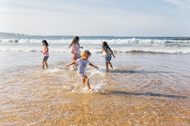 Vier Kinder beim Planschen mit Wasser am Meer - MGOF02853