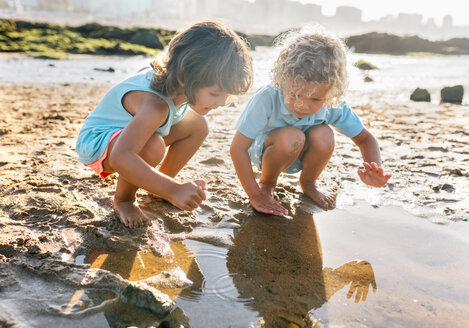 Kleiner Junge und Mädchen spielen zusammen am Strand - MGOF02857