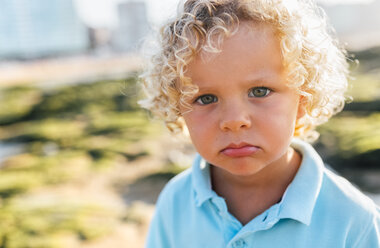 Porträt eines kleinen Jungen mit Schmollmund am Strand - MGOF02860