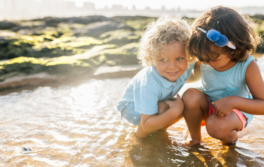 Kleiner Junge und Mädchen spielen zusammen am Strand - MGOF02863