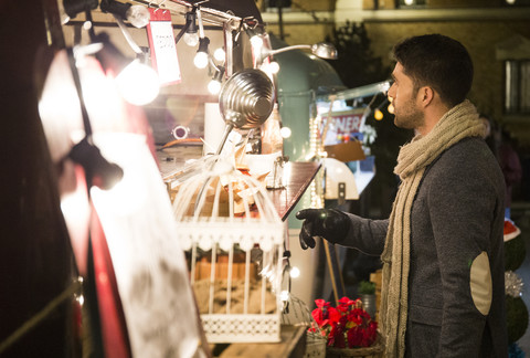 Mann auf einem Weihnachtsmarkt bei Nacht, lizenzfreies Stockfoto