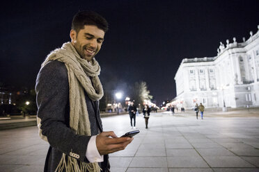 Mann benutzt sein Handy in der Stadt bei Nacht - ABZF01826