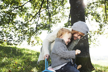 Happy mother with son on tricycle in the nature - FSF00678