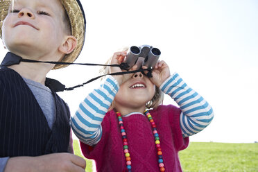 Boy and girl with binoculars on meadow - FSF00682