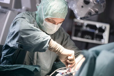 Neurochirurg beim Verschrauben des Schädelknochens während einer Operation - MWEF00134