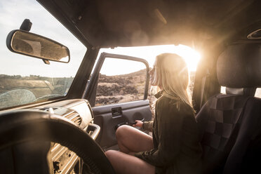 Woman getting on car at sunset - SIPF01385