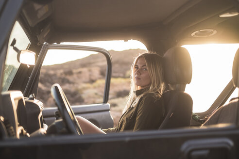 Frau im Auto sitzend bei Sonnenuntergang - SIPF01388