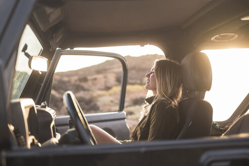 Frau im Auto sitzend bei Sonnenuntergang - SIPF01389