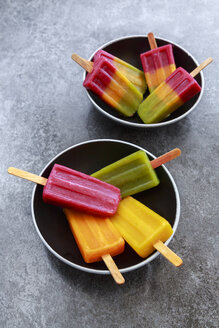 Two bowls of various homemade fruit smoothie ice lollies - SARF03141