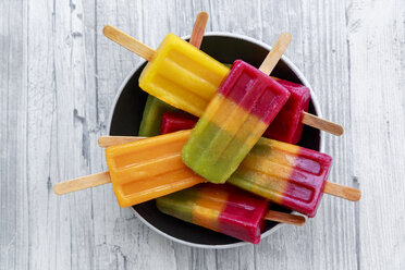 Bowl of various homemade fruit smoothie ice lollies - SARF03145