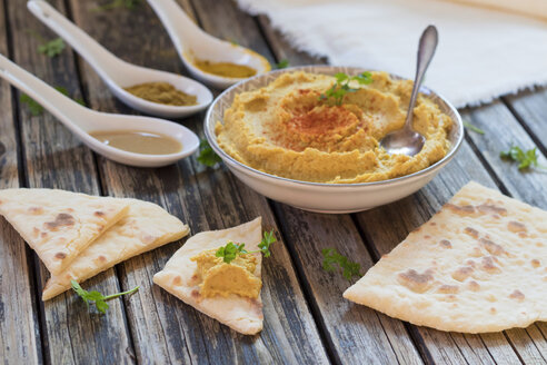 Schale mit Hummus und Fladenbrot auf Holz - YFF00629