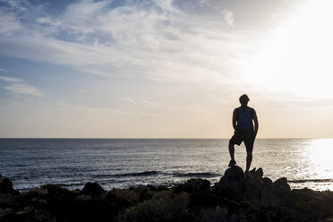 Spain, Tenerife, silhouette of man standing in front of the sea at sunset - SIPF01395