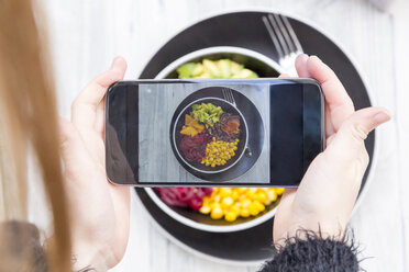 Girl taking a photo of lunch bowl with her smartphone, close-up - SARF03150