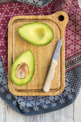 Sliced avocado and knife on chopping board - SARF03156