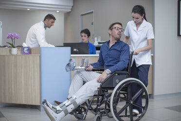 Nurse pushing patient in wheel chair through hospital - ZEF12630