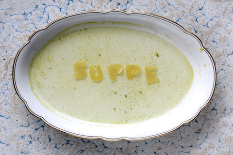 Word 'soup' written with pasta on plate with soup stock photo