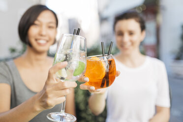 Zwei junge Frauen stoßen mit Cocktails an, Nahaufnahme - ALBF00075