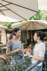 Zwei junge Frauen unterhalten sich in einem Straßencafé - ALBF00076