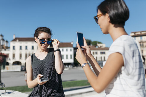 Italien, Padua, junge Frau fotografiert ihren Freund mit dem Smartphone - ALBF00095